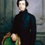 Portrait of Alexis de Tocqueville wearing a black suit and standing in front of a chair.